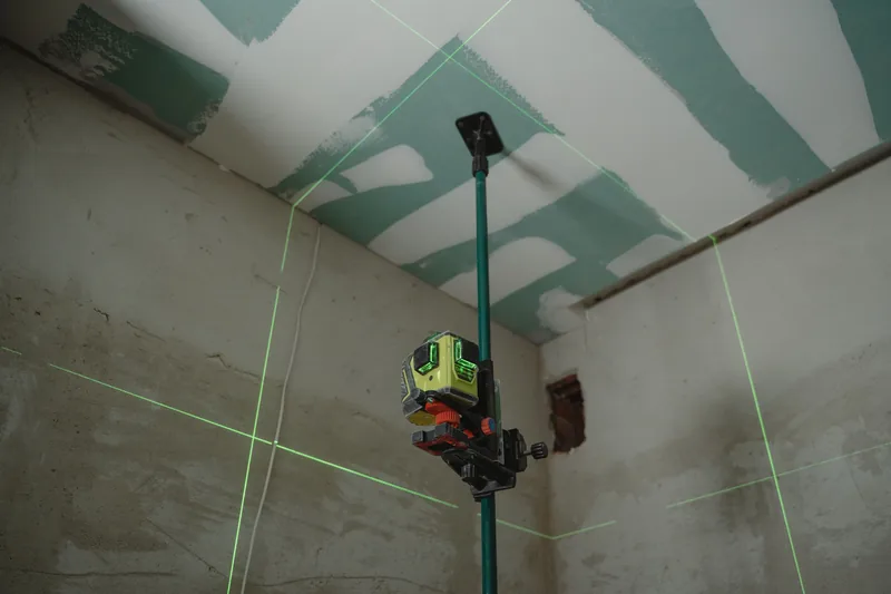 A laser level line set across a wall before installation